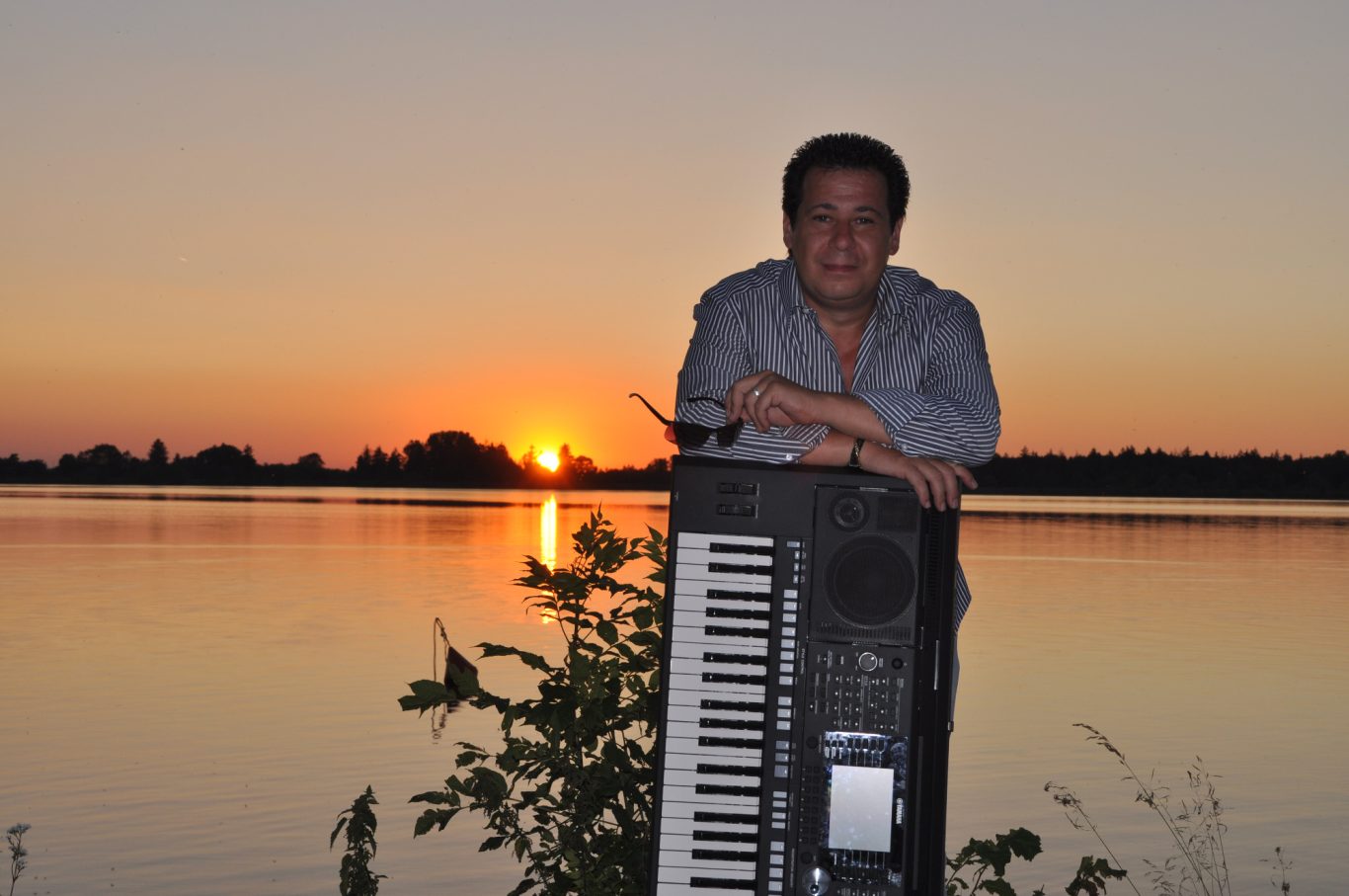 Musiker Adrian Marko am See Der Musiker Adrian Marko mit seinem Keyboard am See